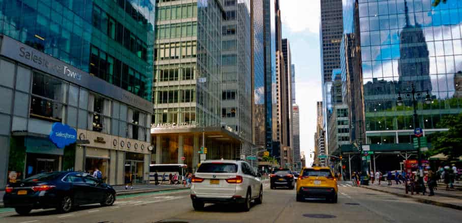 Central Business District in Midtown Manhattan, New York City. A street with cars, a cab and high-rise buildings.