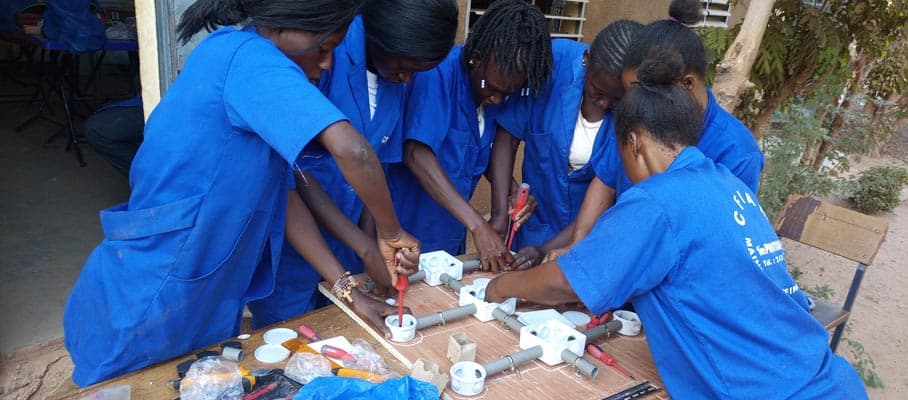 Young women train to fix a motor 