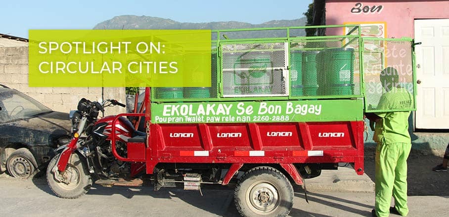 EkoLakay sanitation worker alongside collection vehicle, providing Sanitation Technology in Haiti