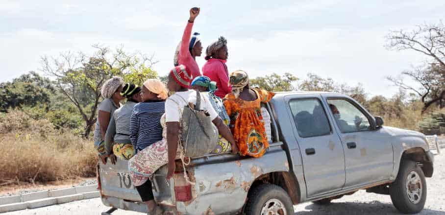 A group of Black women sitting on the back of a pick-up truck