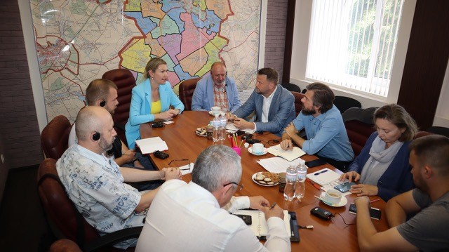 Many people sit around the table and are discussing with the mayor of Vasylkiv.