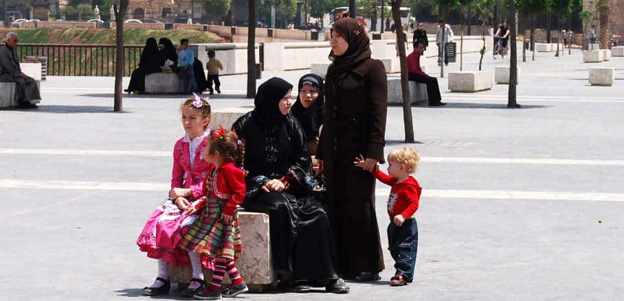 Women with headscarves and kids on a square