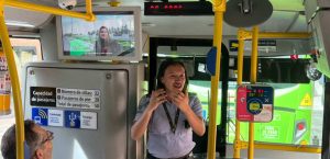 A female Busdriver standing in the bus and talking to the passengers