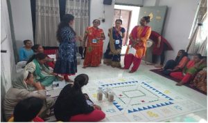Group of women in a room with a game board on the floor in front of them