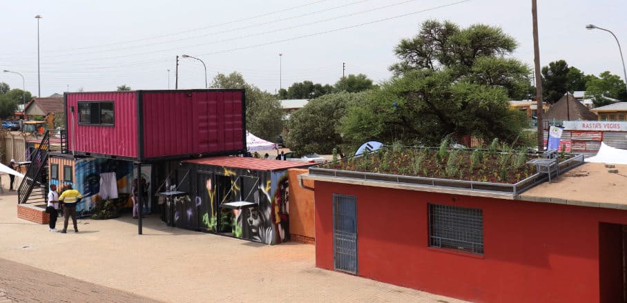 Colourfully painted containers on the side of a road representing the new traders hub