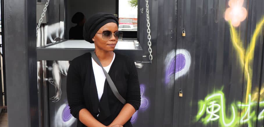 Mpho Mojakwe stands outside of the container