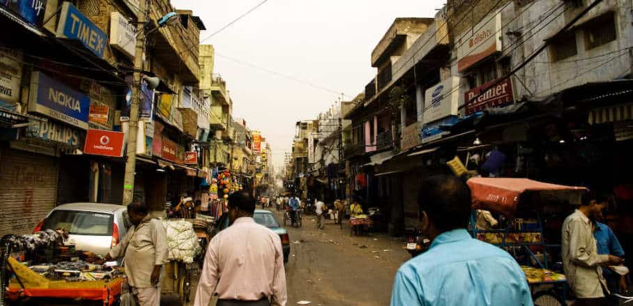 A narrow street in India with various little shops left and right